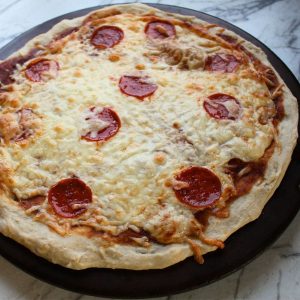 Pepperoni pizza on a pizza stone.