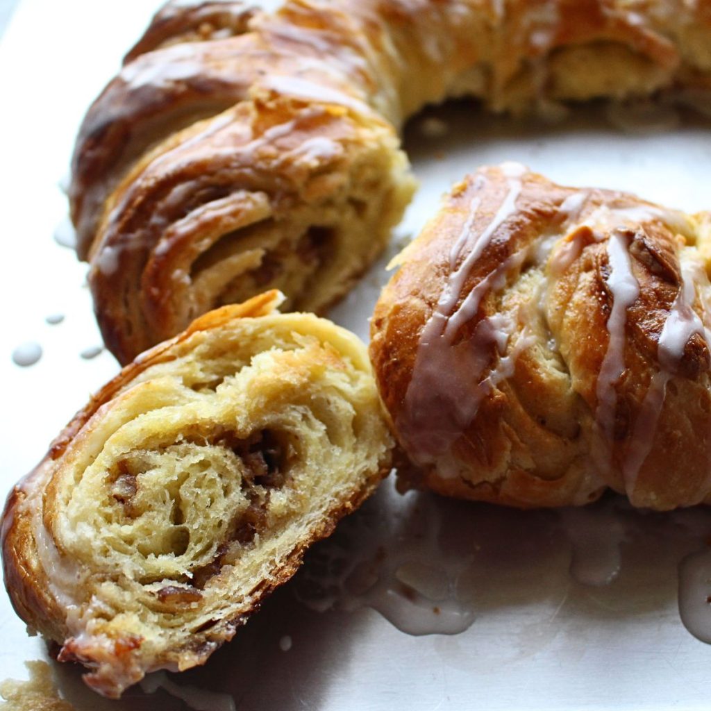 A piece of Swedish cardamom coffee cake tea ring cut out from the bigger ring.