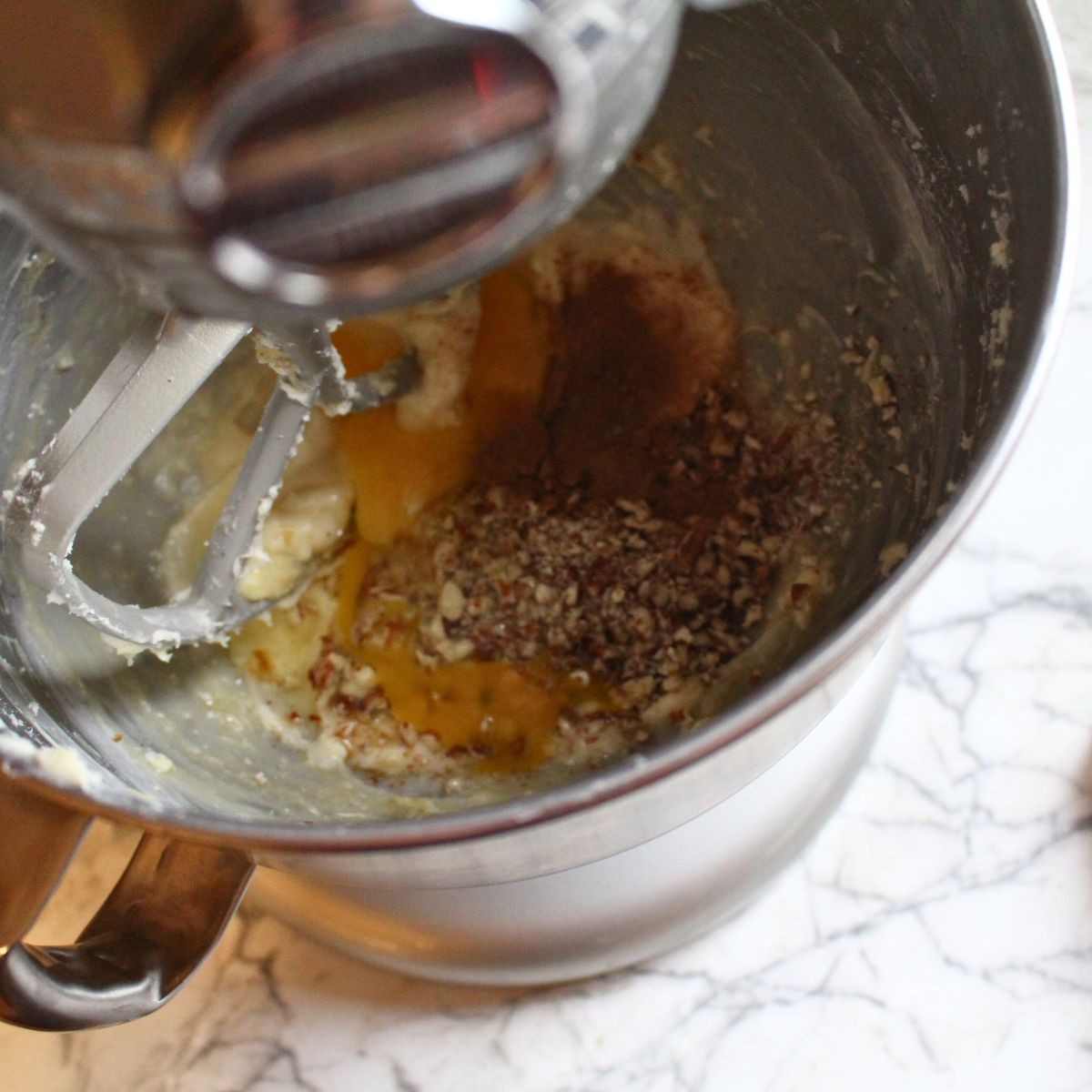 A overhead shot of a kitchen aid mixer in the process of mixing the filling for the Swedish cardamom coffee cake.