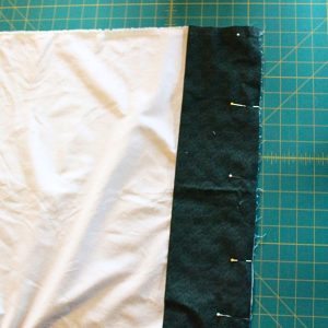 A close up showing the constrasting band, trim and pillowcase body all pinned together.