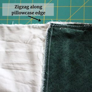 A close up of the zigzag stitch sewed along the the pillowcase edge with instructions at the top.