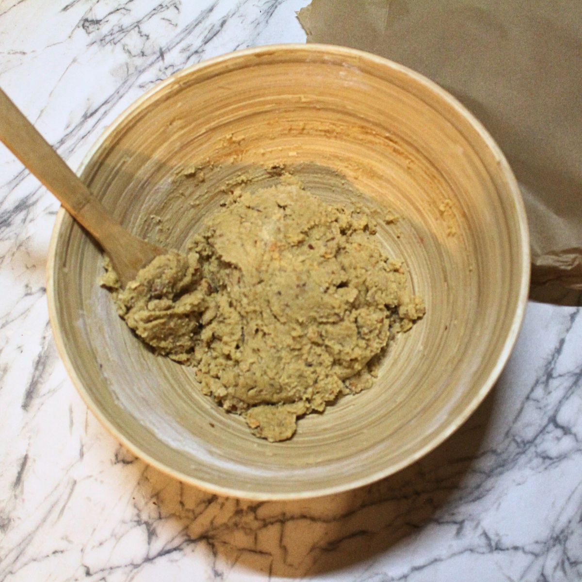A wooden bowl with Almond Icebox cookie dough in it.