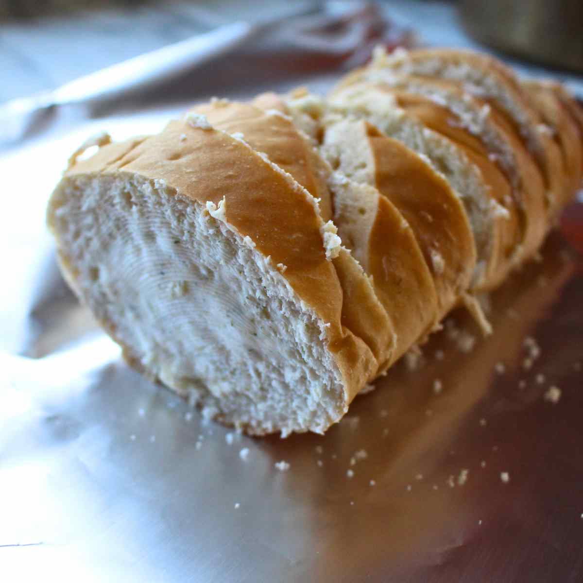 French bread loaf slices spread with garlic butter for homemade garlic bread.