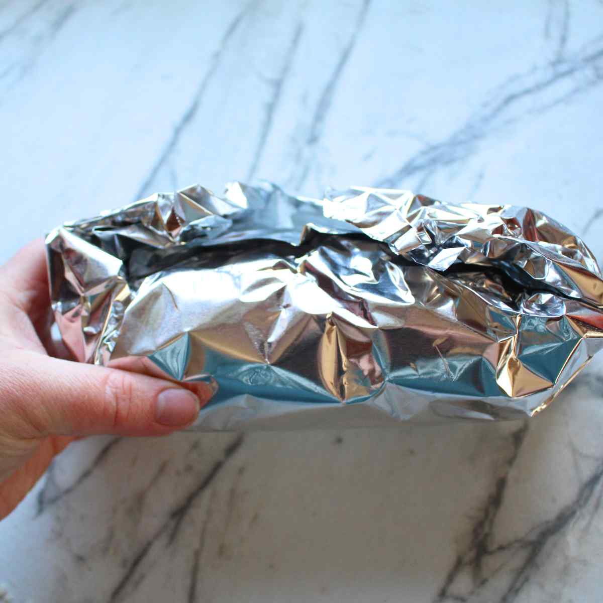 Homemade garlic bread wrapped in aluminum foil before being put in the oven.