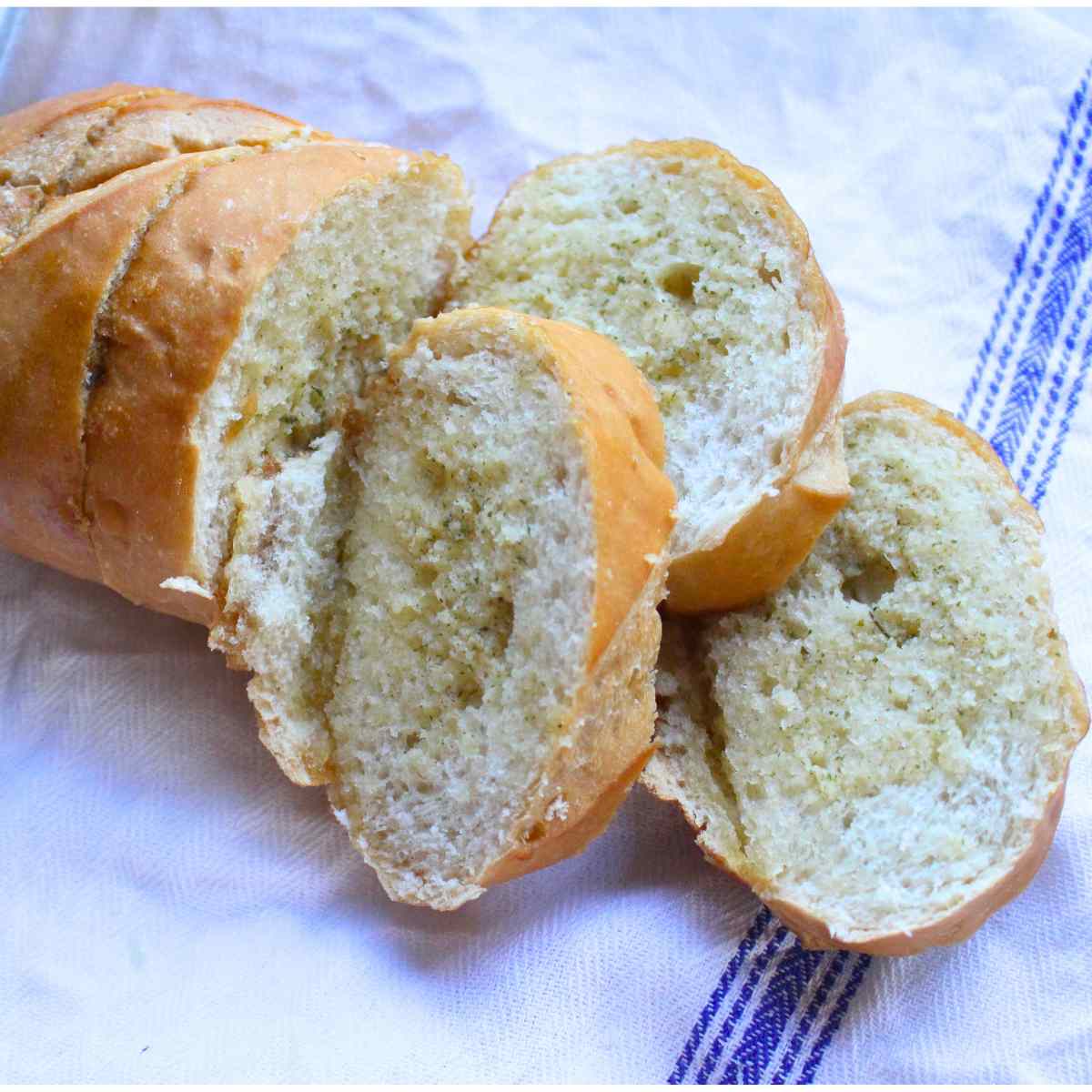 Homemade garlic bread loaf with three slices off the loaf to show the middle.
