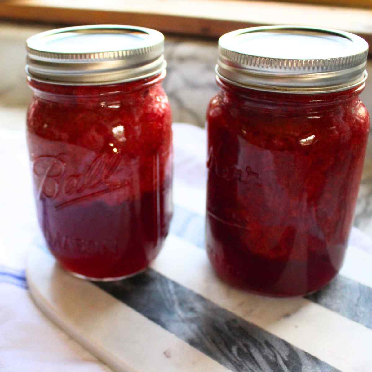 Two pint jars of strawberry sauce.