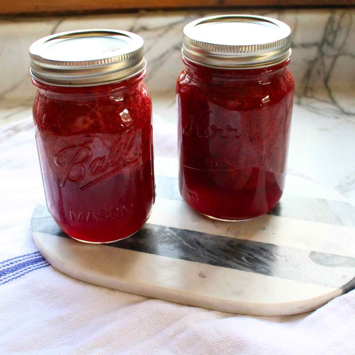 Two pint jars of strawberry sauce.