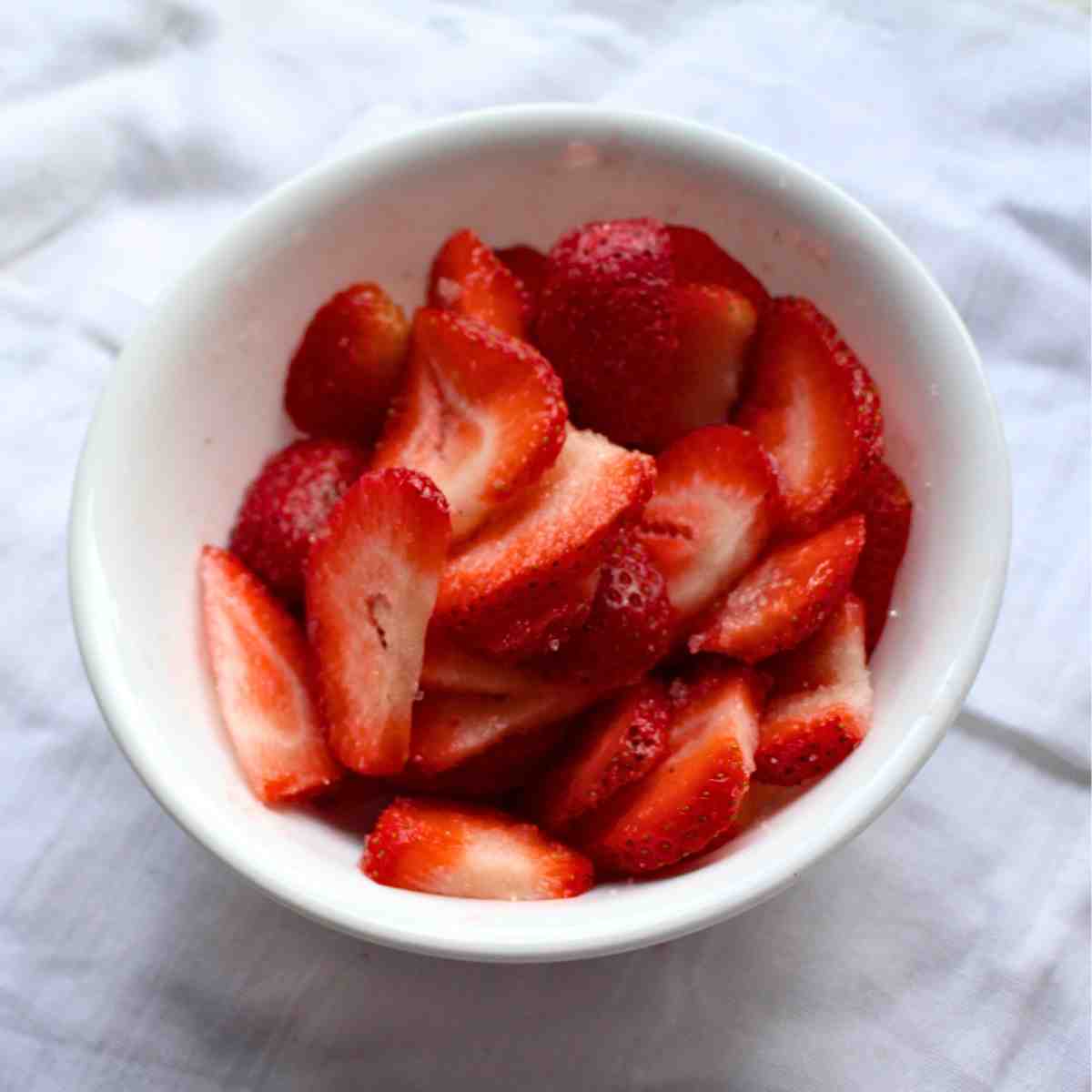 A bowl filled with sliced strawberries.