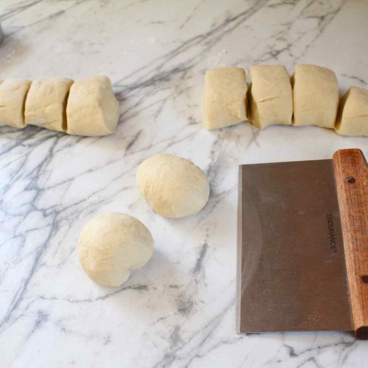 Dough pieces being shaped into dinner rolls for 1 hour dinner rolls.
